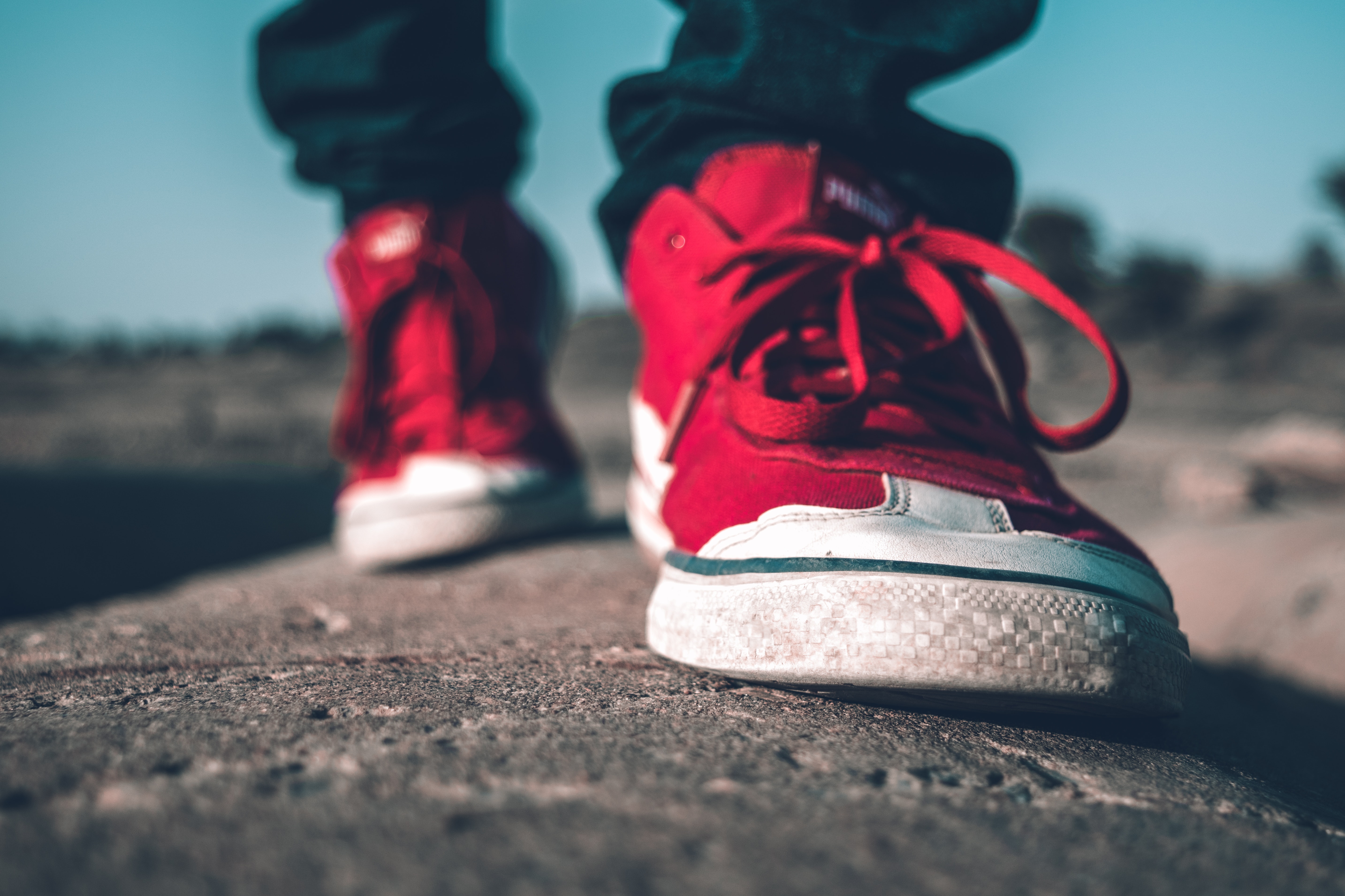 Red trainers walking on hard ground
